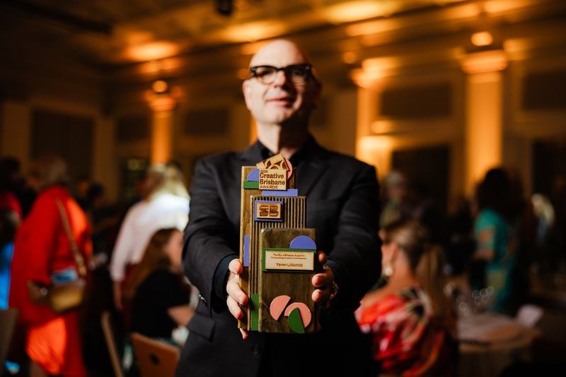 A recipient holding his stacked 2026 Creative Brisbane Award at the gala ceremony.