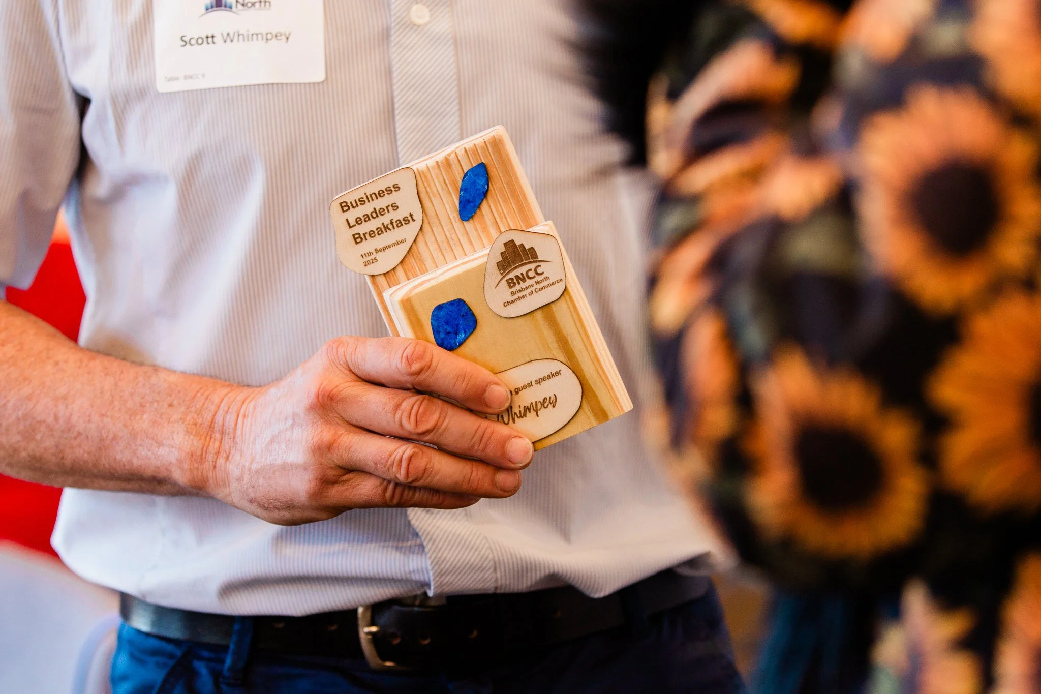 A guest speaker holding his Brisbane North Chamber of Commerce Business Leaders Breakfast trophy at the event.