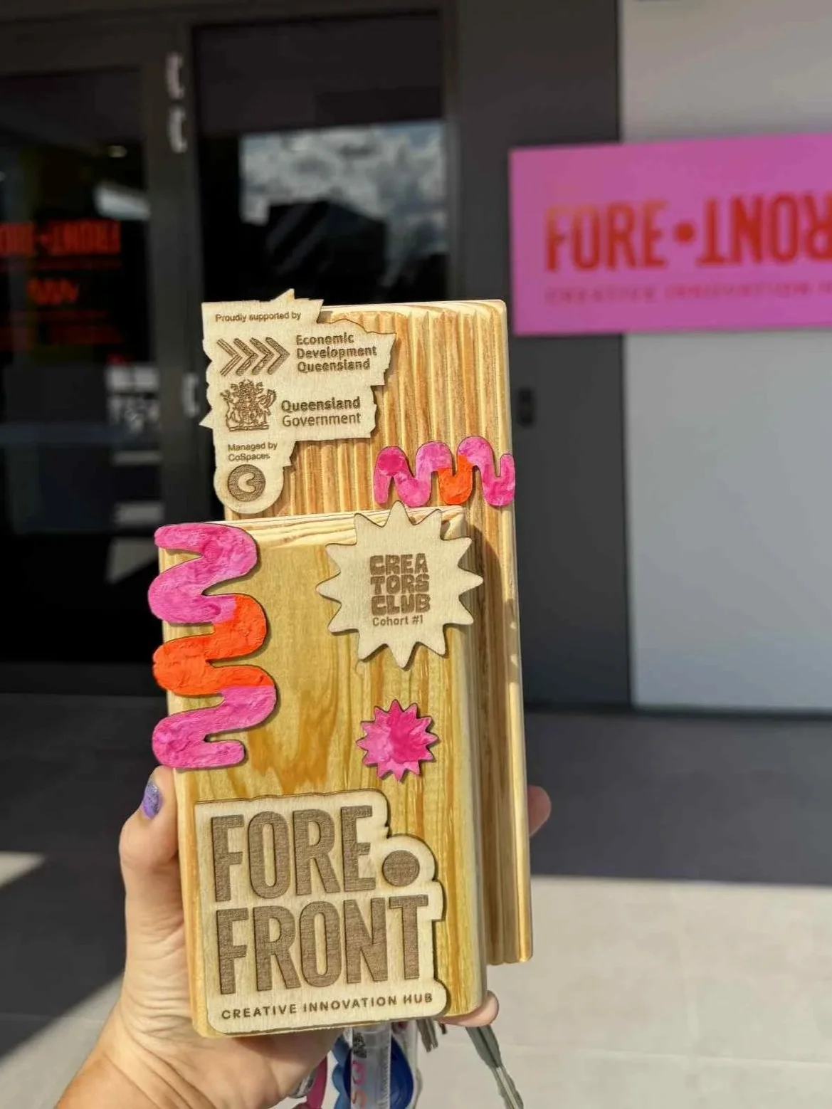 Forefront Creative Innovation Hub trophy with hand-painted pink and orange squiggles, supported by Economic Development Queensland and Queensland Government.