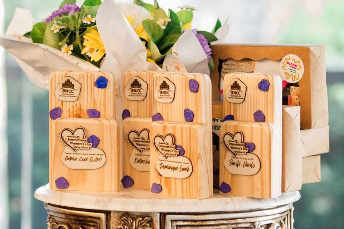 Brisbane North Chamber of Commerce International Women's Day Long Lunch speaker awards and gift boxes in pine, finished with purple inlays and fresh flowers.