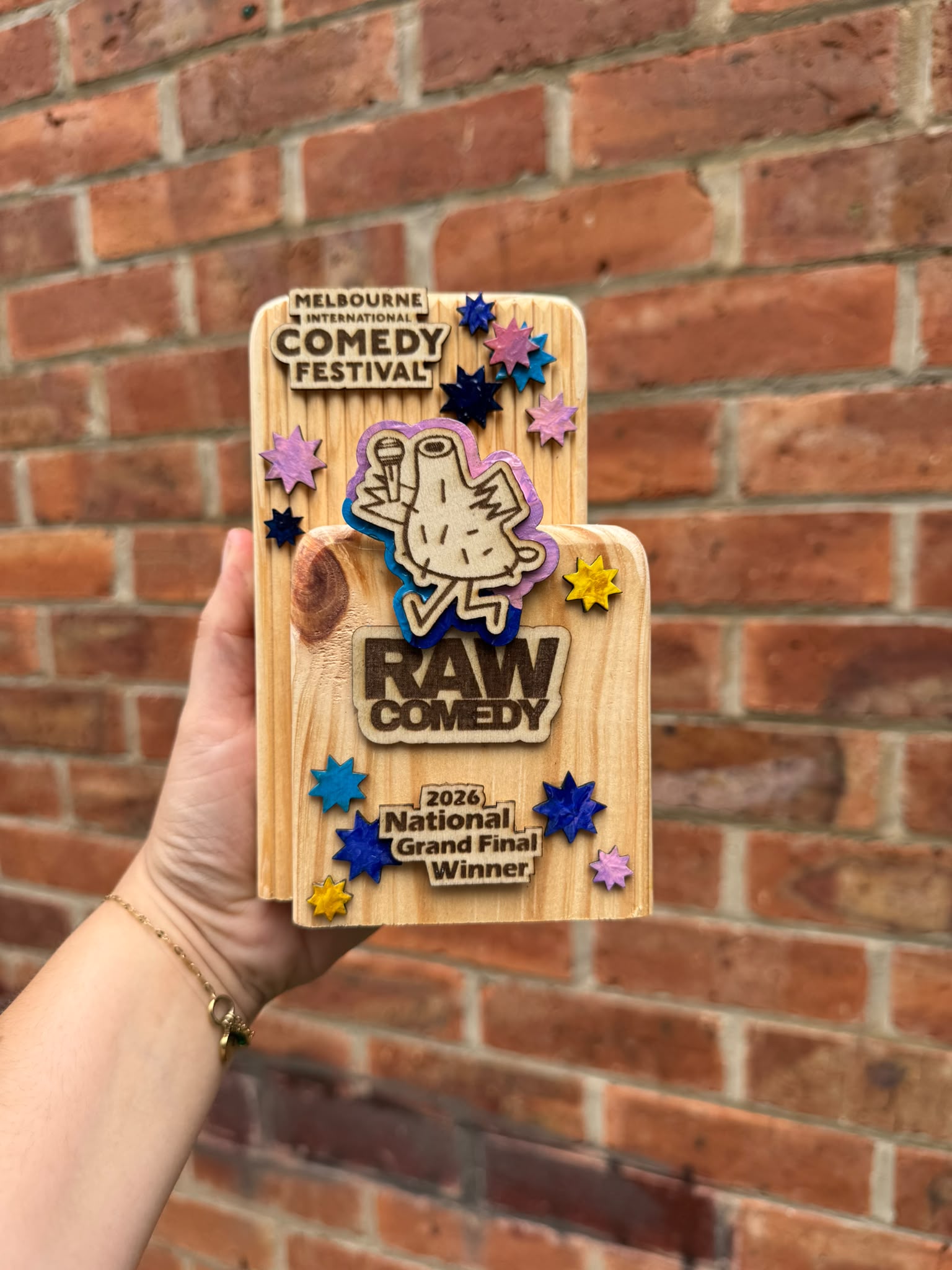 A Raw Comedy National Grand Final winner trophy showing the timber grain and knot.